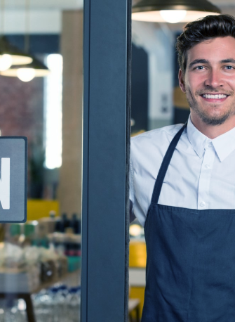 man in an apron smiling a the camera