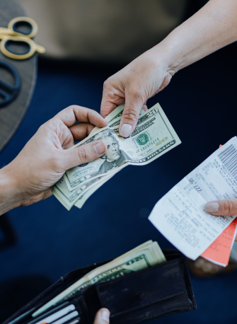 a person's hand passing money to another person